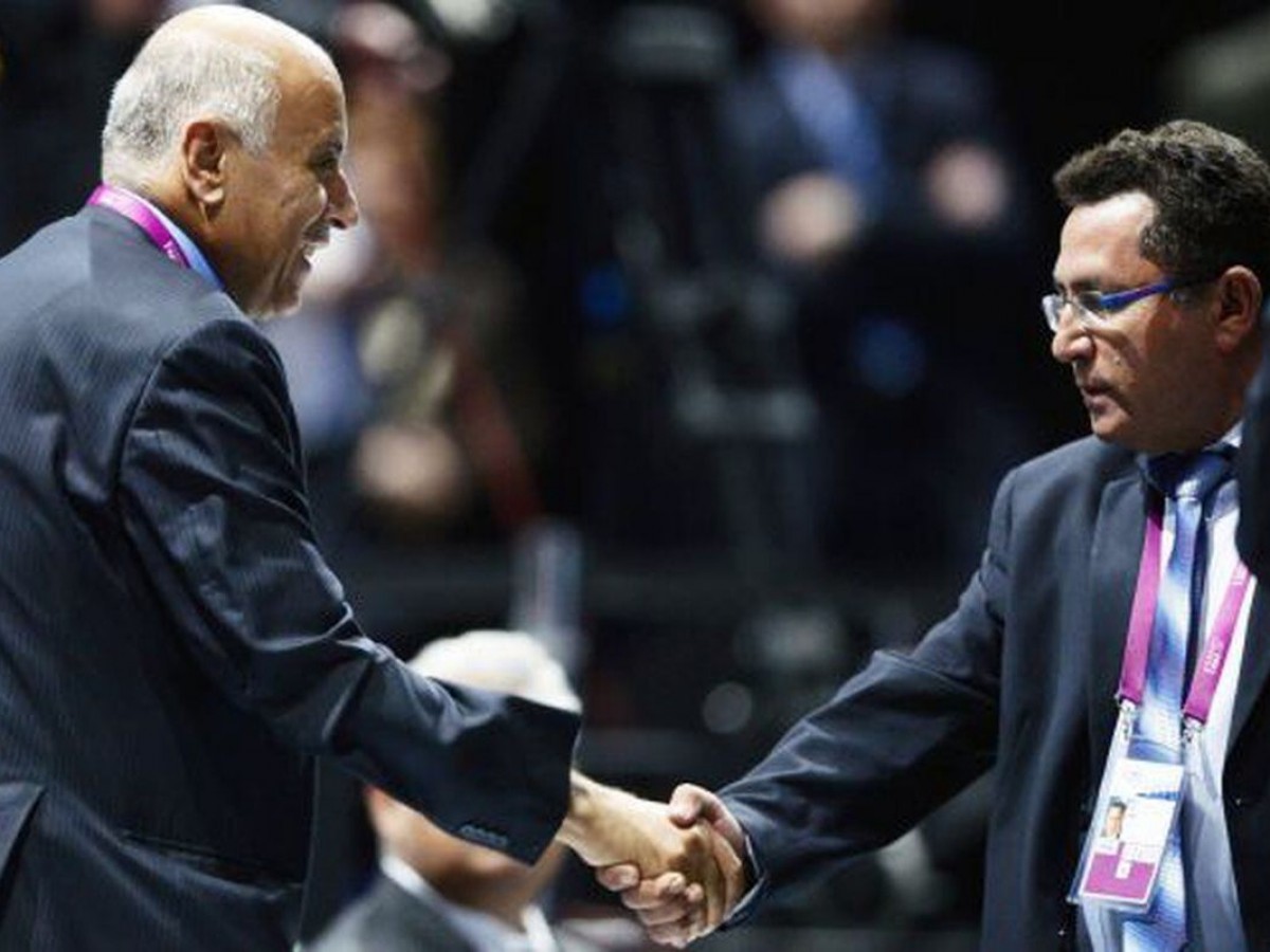The president of the Israeli Football Association shakes hands with his Palestinian counterpart.