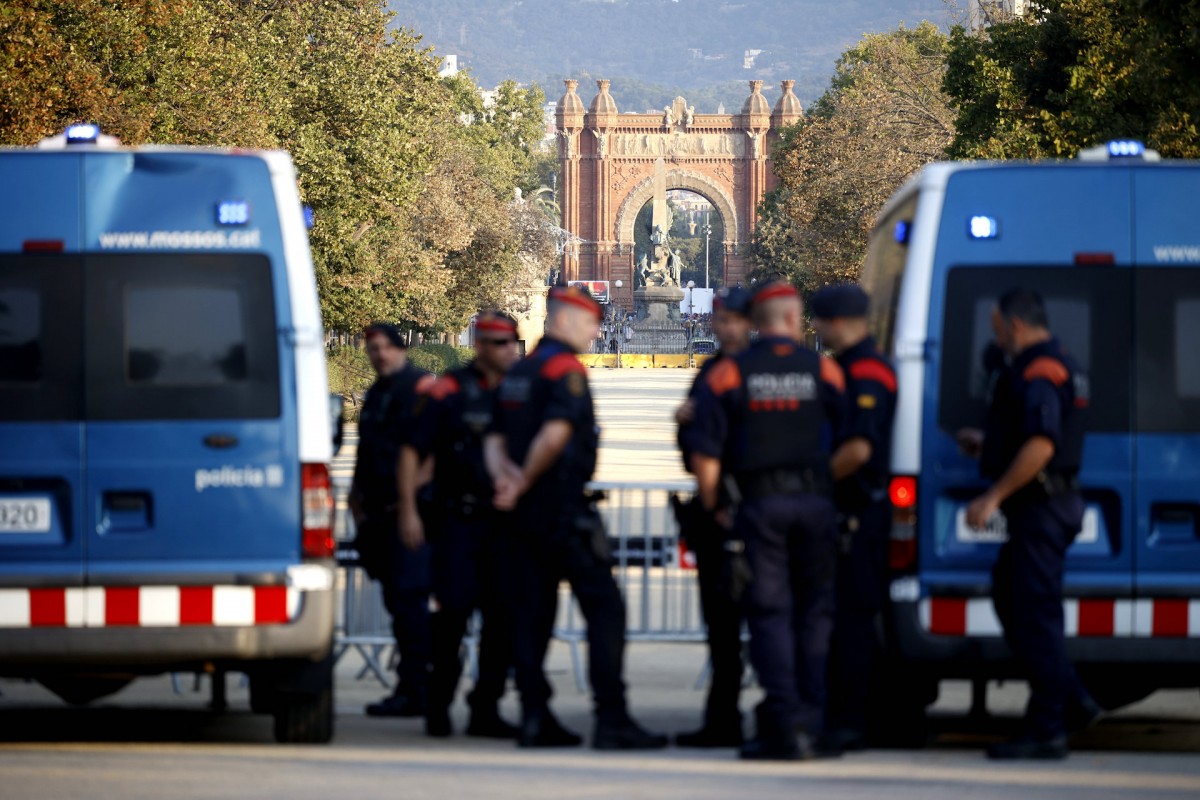Agentes de los Mossos d' Esquadra y varias personas en las inmediaciones del Parlament de Cataluña, en el parque de la Ciutadella.