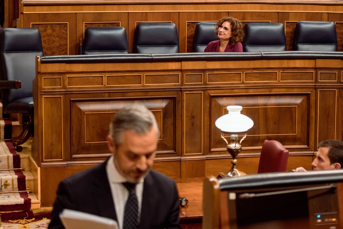 La vicepresidenta cuarta y ministra de Hacienda y Función Pública, María Jesús Montero, asiste a la intervención del diputado del Partido Popular, Juan Bravo Baena, durante una sesión de control en el Congreso de los Diputados.