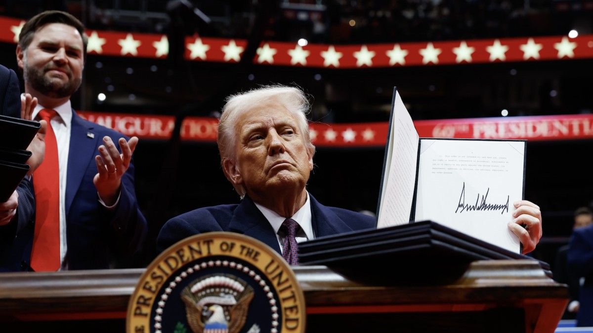  Donald Trump, acompañado por su vicepresidente J. D. Vance, exhibe una orden ejecutiva ante el público del Capital One Arena durante la celebración de su toma de posesión.