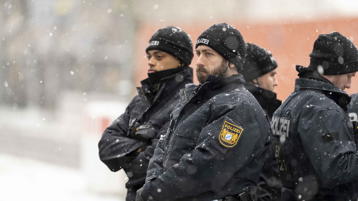 Agentes de policía guardan un minuto de silencio el día posterior al ataque terrorista de Múnich en el lugar del atentado.