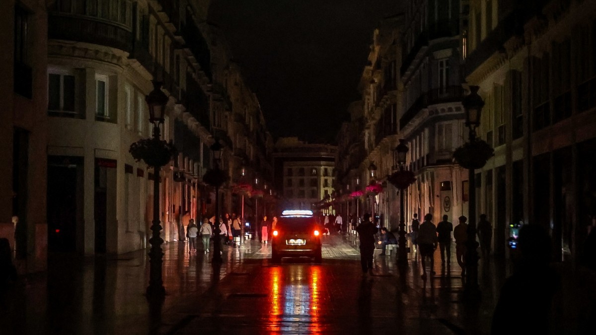 Un coche de policía recorre las calles de Málaga durante el apagón.