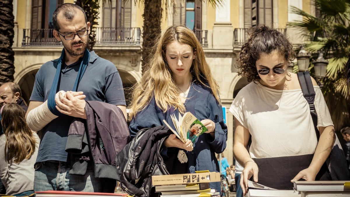 Jóvenes examinan ejemplares durante el Día de Sant Jordi, en Barcelona.