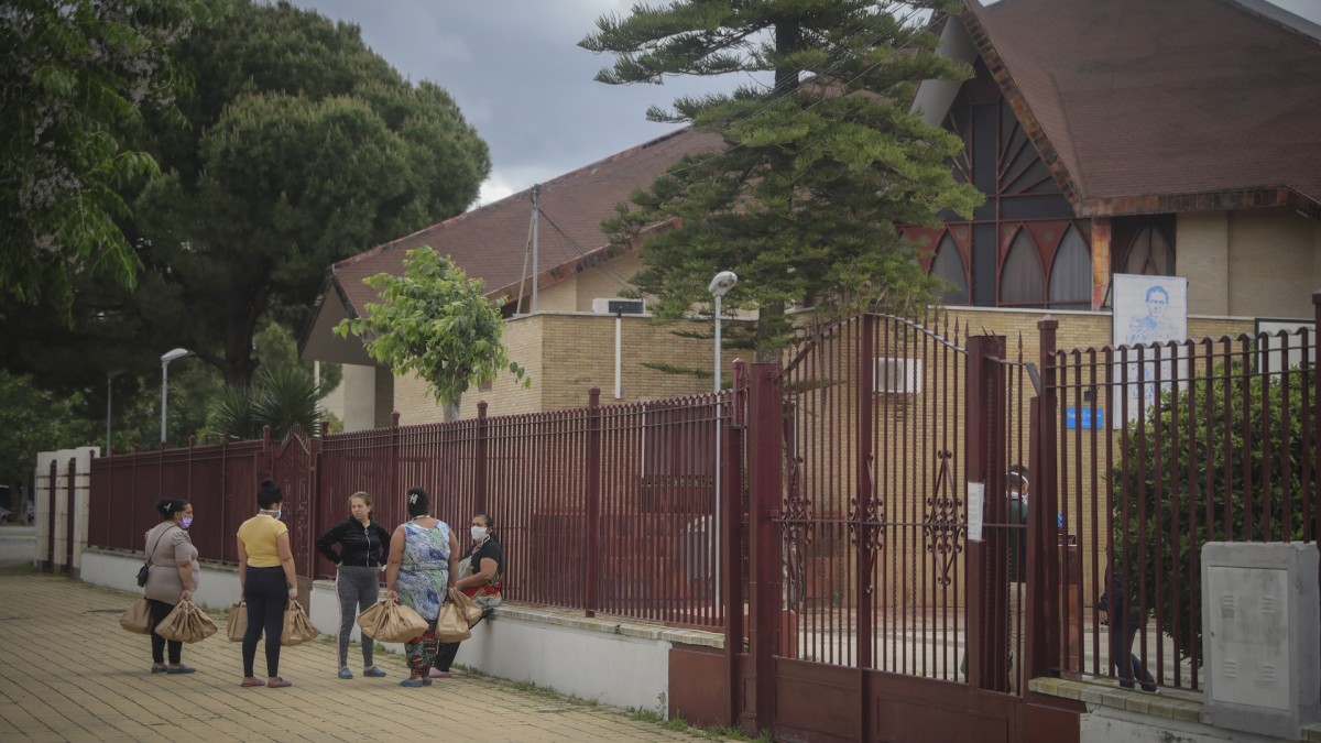 Un grupo de mujeres conversan en la calle tras la entrega de alimentos Proyecto Fraternita a familias vulnerables de dos de los barrios más pobres de España, el Polígono Sur y Tres Mil Viviendas de Sevilla.