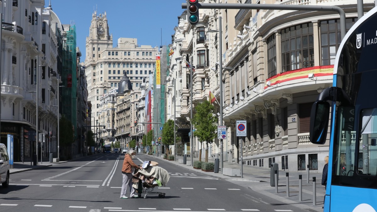 Una persona sin hogar cruza la Gran Vía  de Madrid durante el confinamiento.
