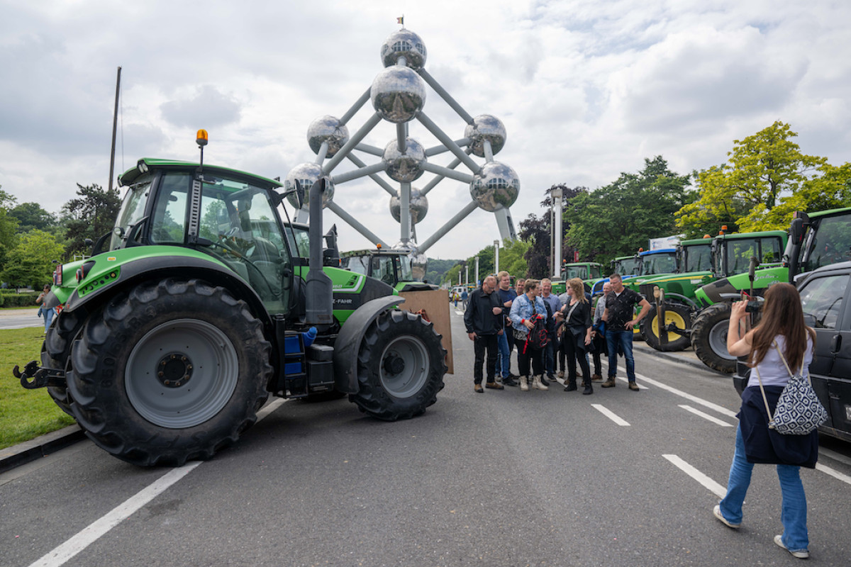 Agricultores protestando y tomando fotos frente al Atomium durante una acción de protesta de varias asociaciones de agricultores europeos en Bruselas.