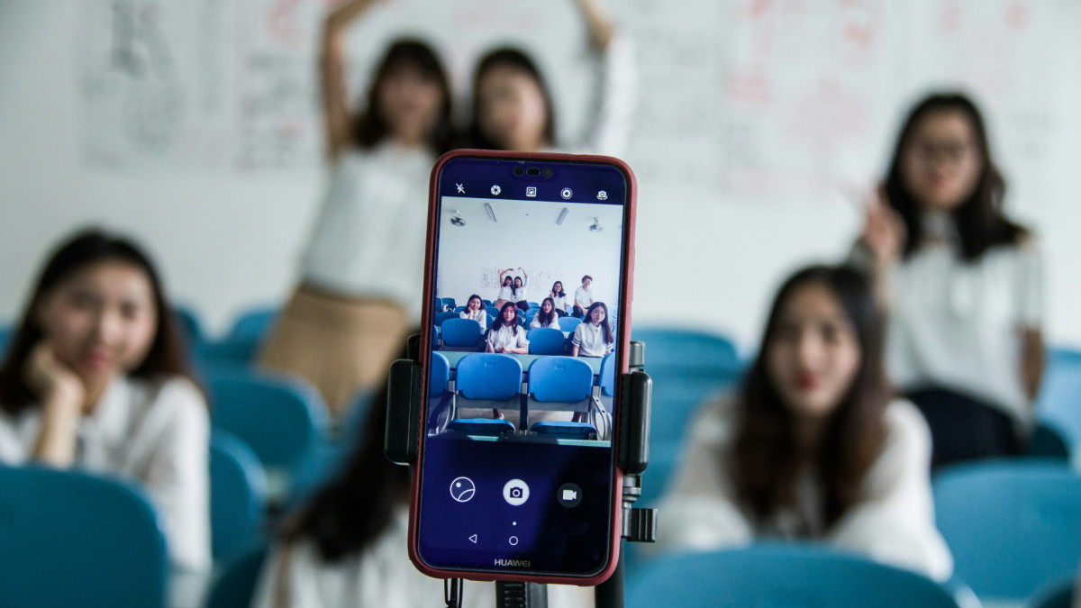 Alumnas se fotografían con un teléfono móvil en la escuela.