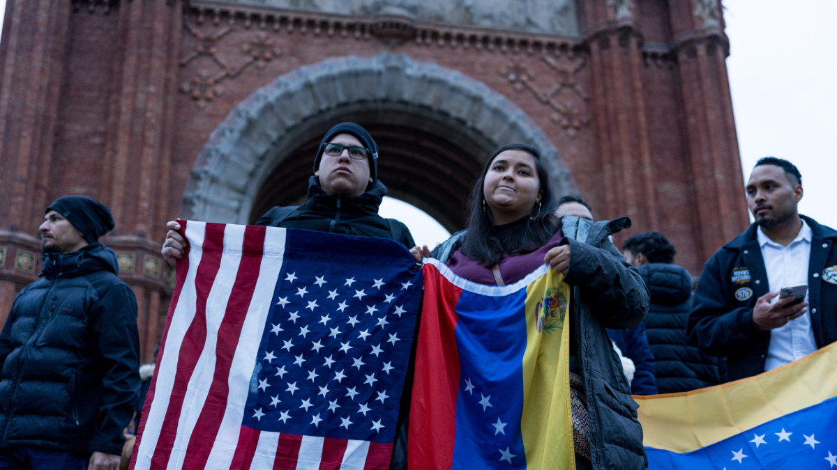 Manifestantes exhiben la bandera de Estados Unidos junto a la de Venezuela en Barcelona.