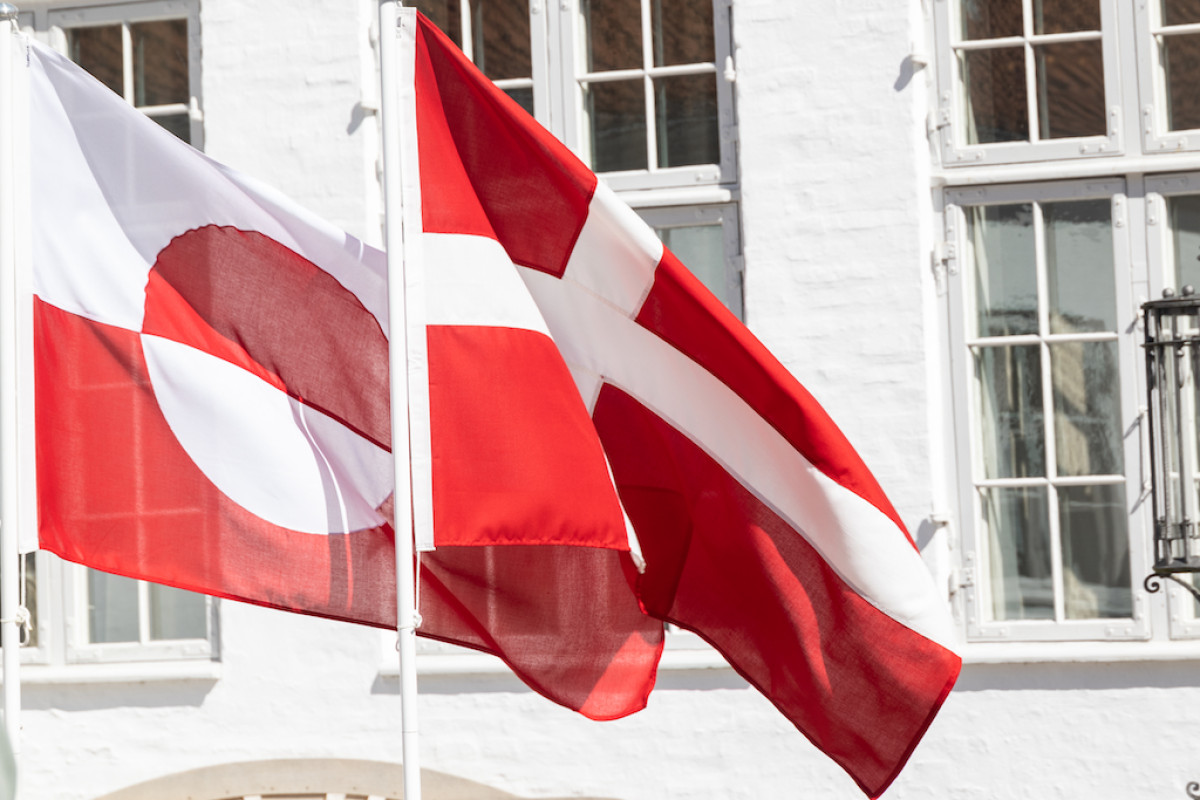 The flags of Greenland and Denmark fly at a joint press conference with Prime Ministers Jens-Frederik Nielsen and Mette Frederiksen.