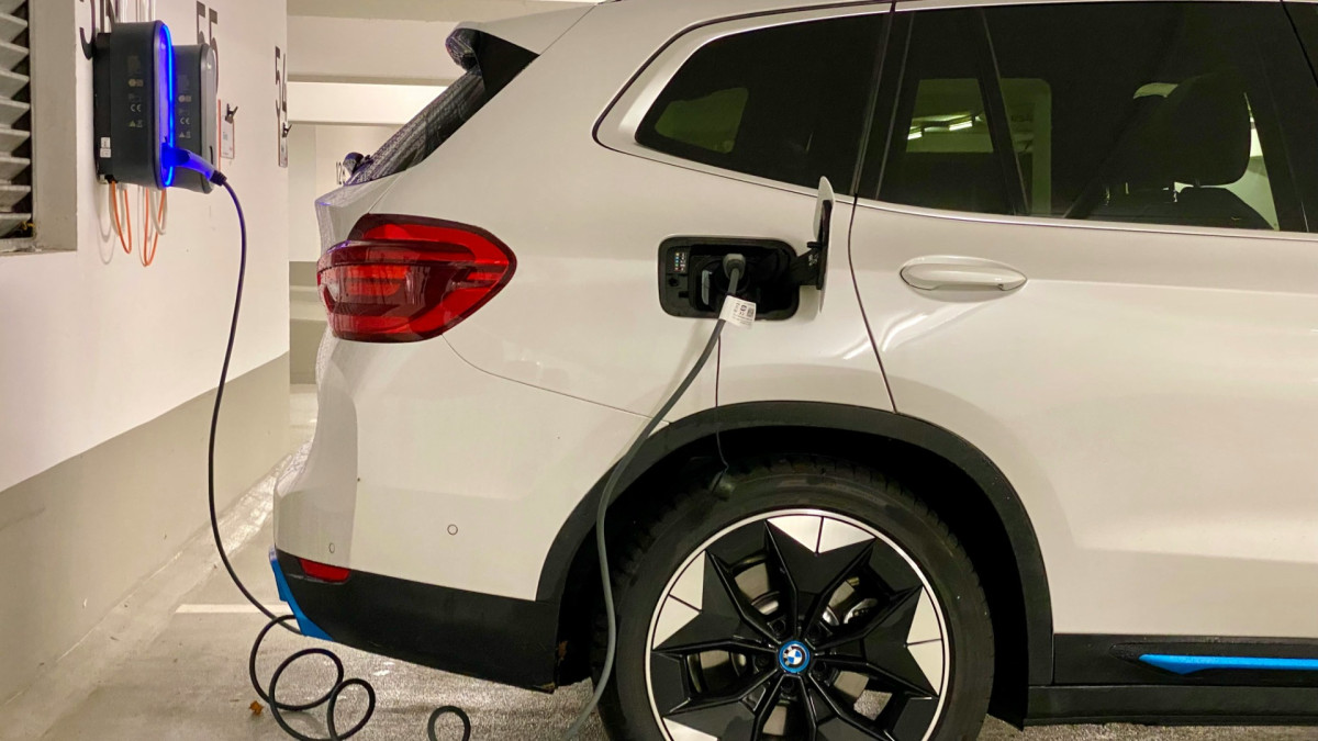 Un coche eléctrico enchufado en una estación de carga. 