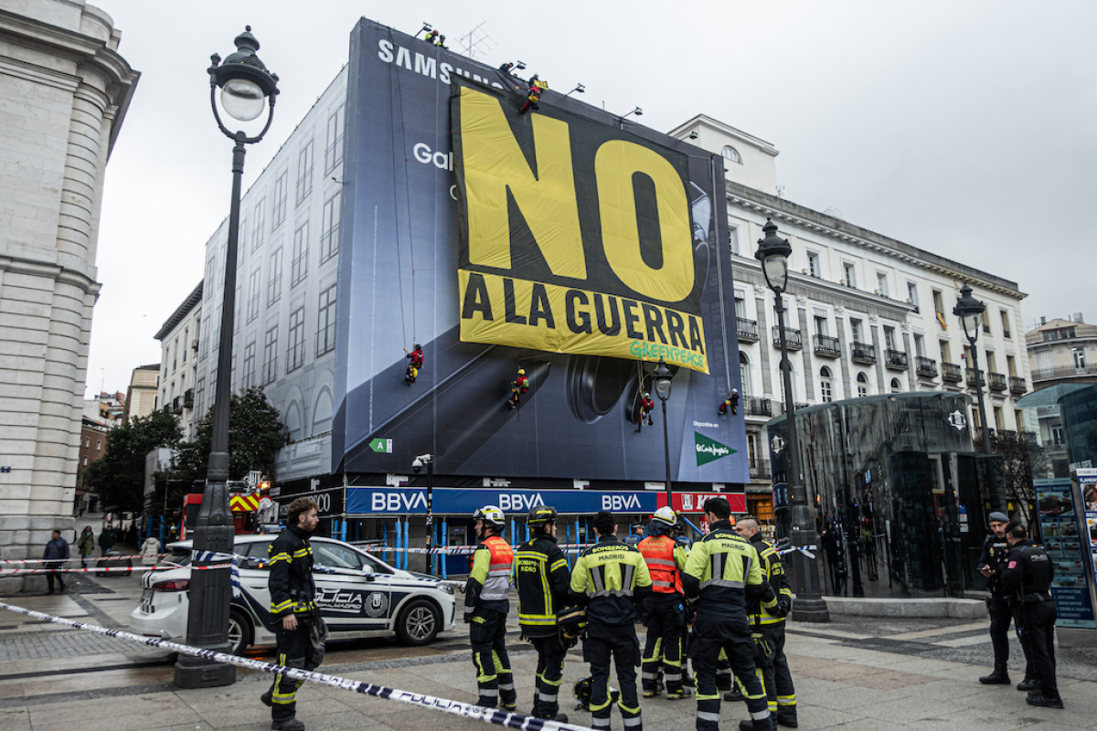 Greenpeace takes down a huge banner in Sol featuring the slogan 'No to war'.