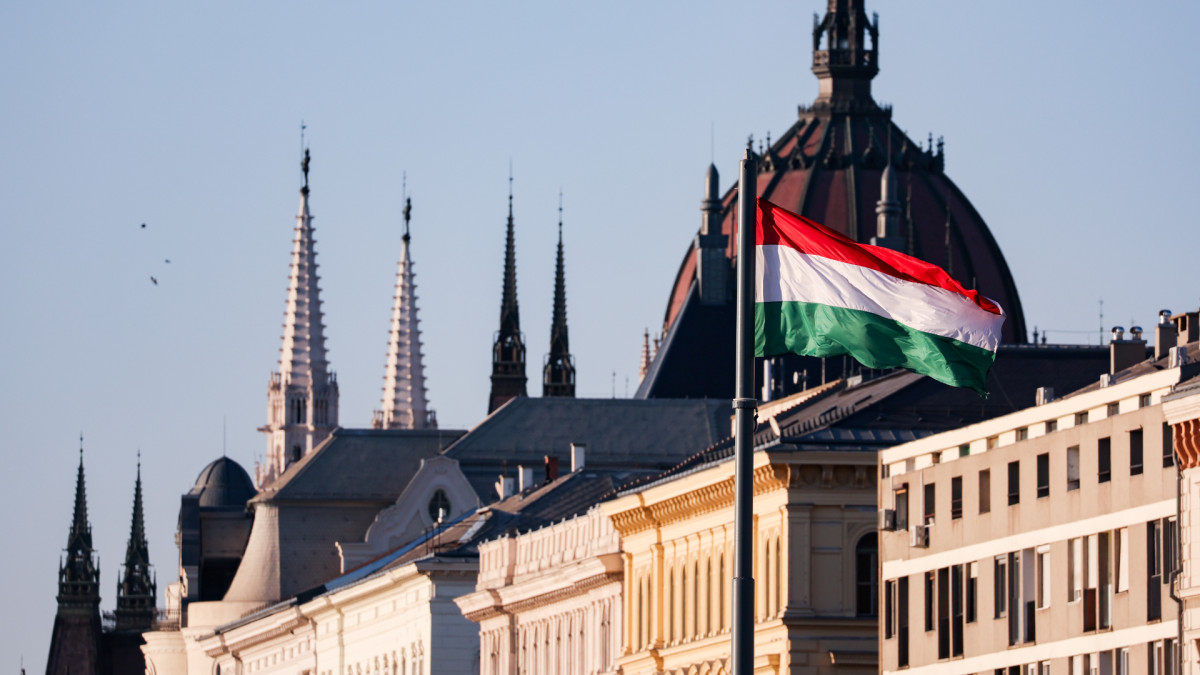 Una bandera ondea en Budapest a escasos días de las elecciones con el Parlamento de Hungría de fondo.