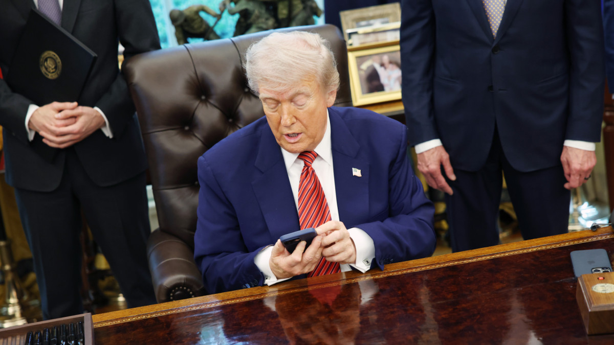U.S. President Donald Trump uses his mobile phone in the Oval Office.