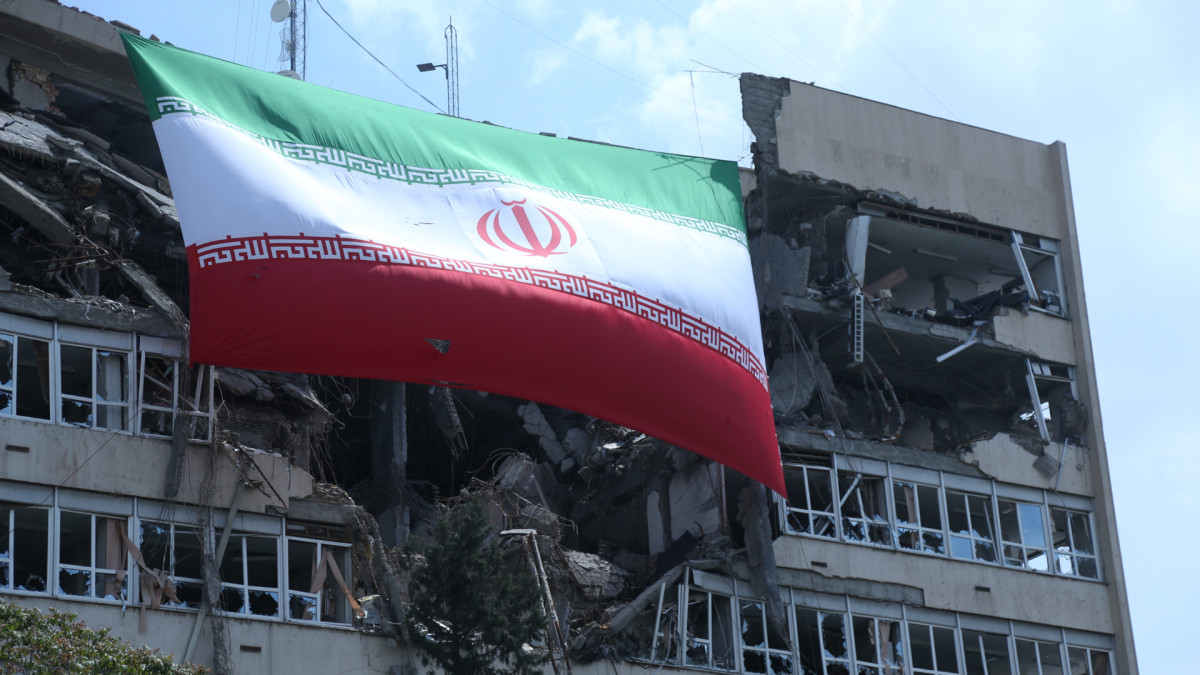 La bandera oficial de Irán ondea sobre un edificio semiderruido en Teherán 