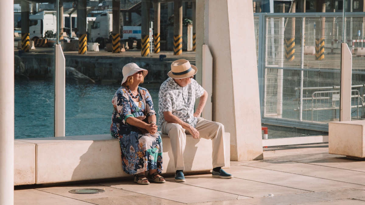 Dos personas mayores sentadas junto al mar en Málaga.