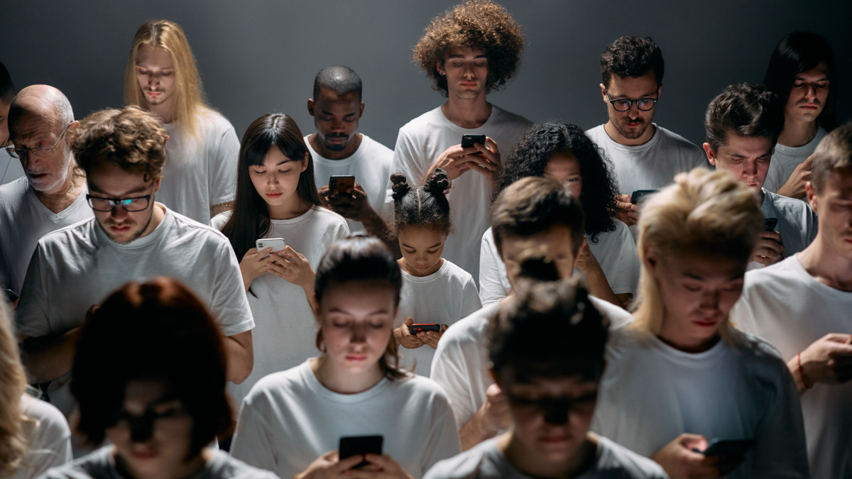Un grupo de personas jóvenes atendiendo a sus teléfonos.