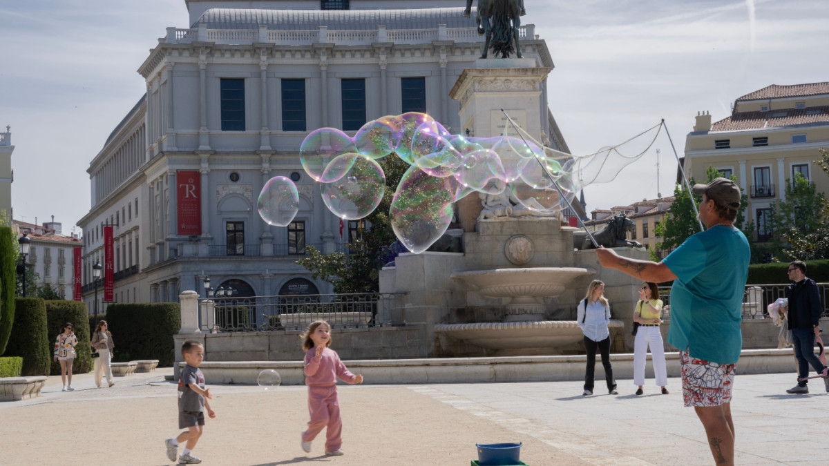 Niños juegan frente al Teatro Real de Madrid.