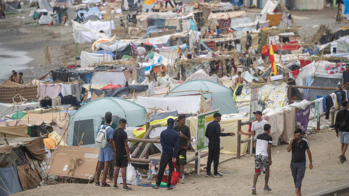 Varios inmigrantes acampados en una playa, a 1 de septiembre de 2026, en Ceuta (España).