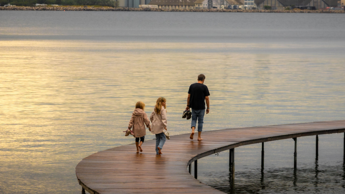 Una familia pasea junto a una zona industrial. Más allá de las aulas, el entorno socioeconómico y laboral condiciona también la experiencia educativa.