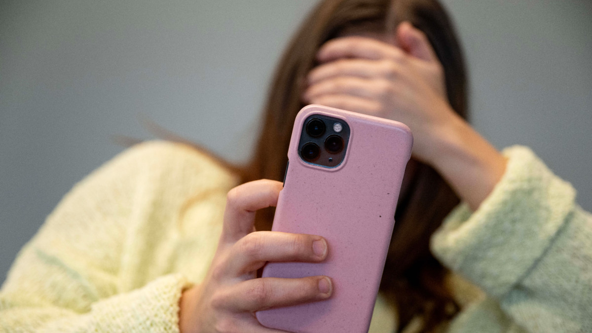 Una menor de edad con un teléfono móvil.
